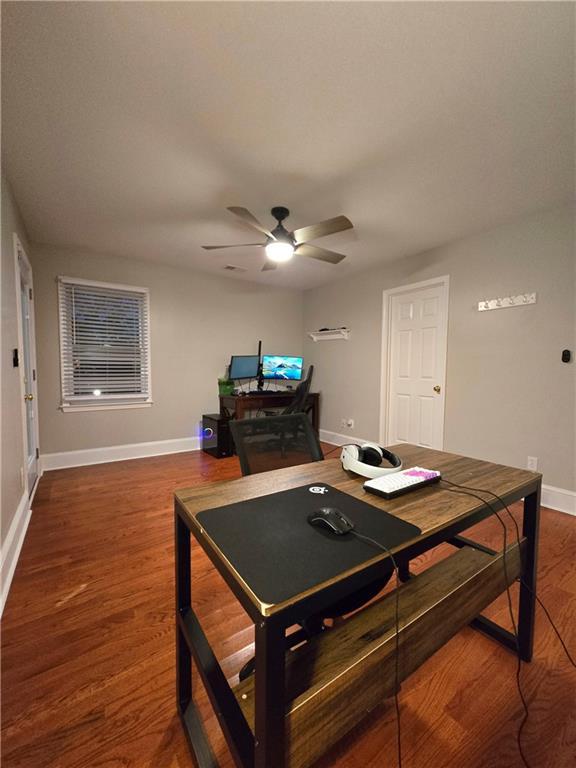 interior space featuring a ceiling fan, baseboards, and wood finished floors