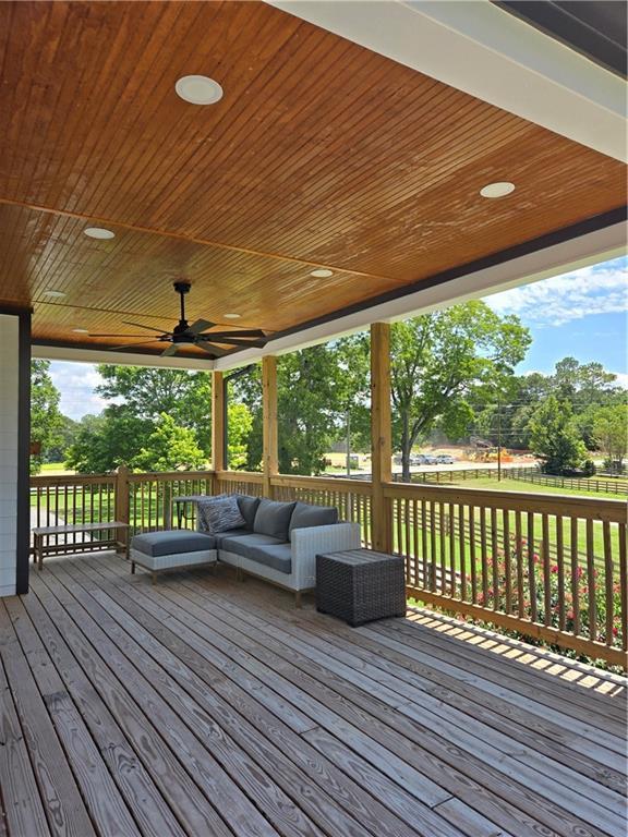 wooden deck featuring outdoor lounge area and ceiling fan