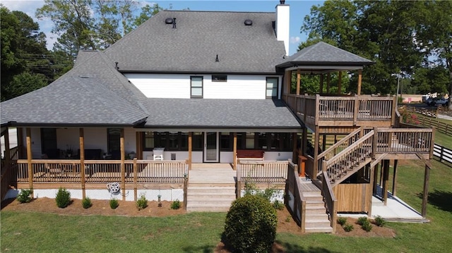 rear view of house featuring a lawn and a wooden deck