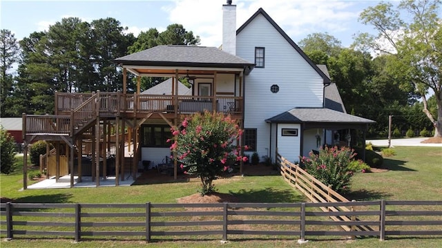 view of front of home with ceiling fan, a patio, a wooden deck, and a front lawn