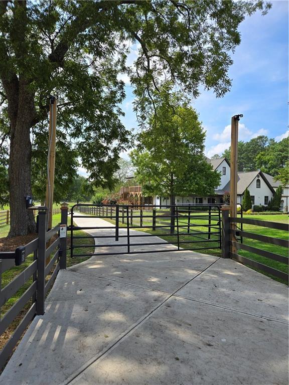 view of home's community with a gate, fence, and a yard