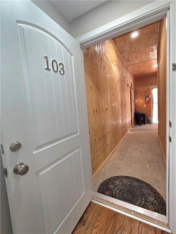 corridor with wood walls and wood finished floors