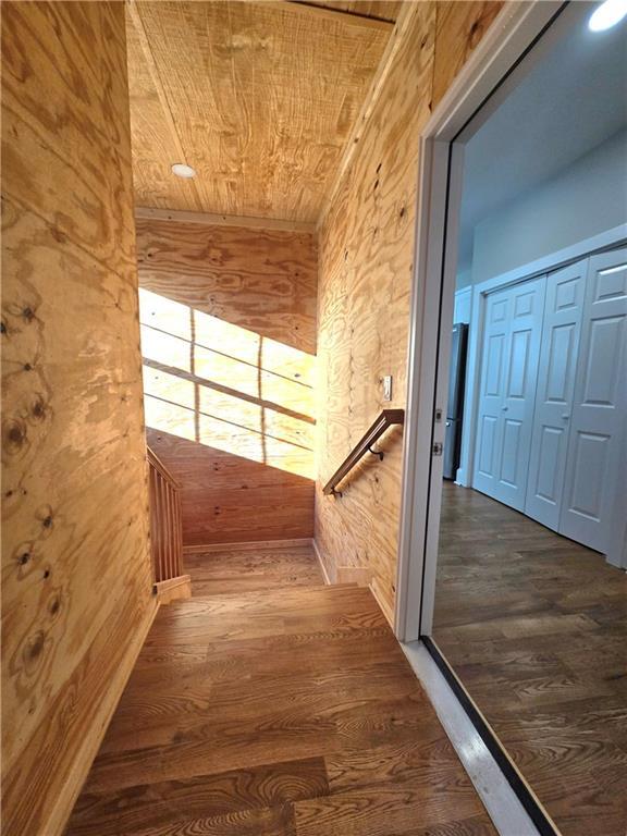 hall featuring dark hardwood / wood-style flooring and wooden ceiling