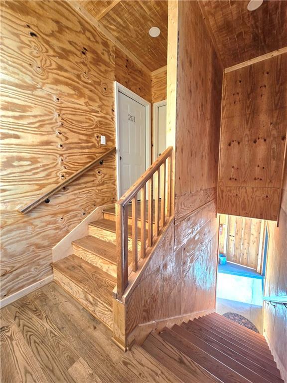 entryway featuring hardwood / wood-style floors, wooden ceiling, and wood walls