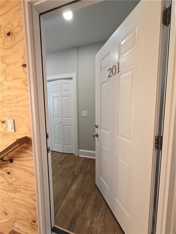 hallway with baseboards and dark wood-type flooring