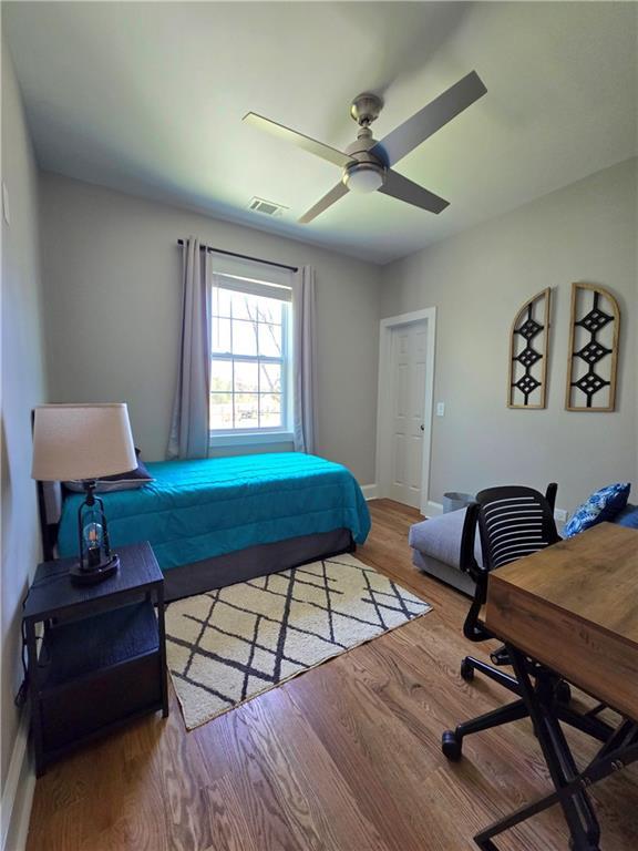 bedroom with ceiling fan and hardwood / wood-style floors