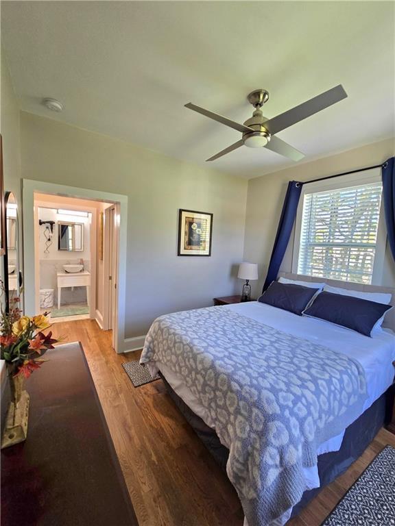 bedroom featuring ceiling fan, baseboards, connected bathroom, and light wood-style floors