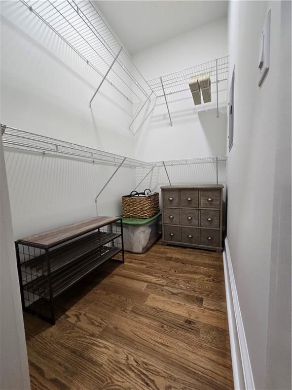 clothes washing area with dark hardwood / wood-style floors and stacked washer / dryer