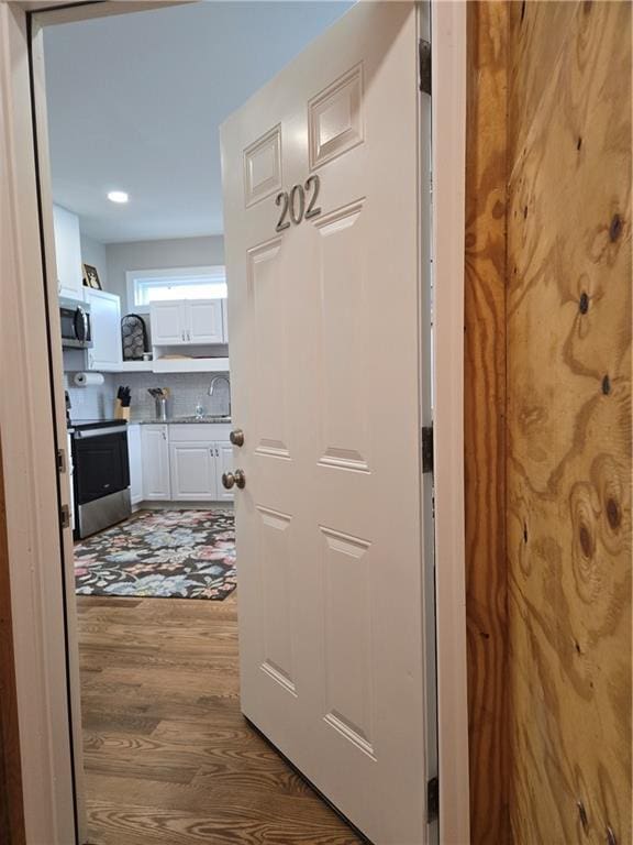 hallway with sink and dark wood-type flooring