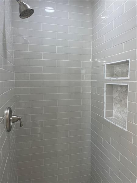 interior details with a tile shower