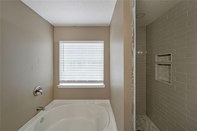 bathroom with separate shower and tub and a textured ceiling