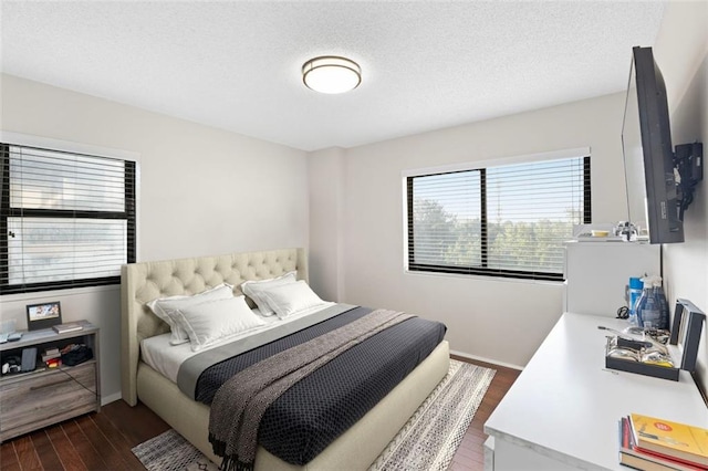 bedroom featuring dark hardwood / wood-style flooring and a textured ceiling