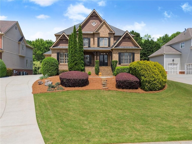 craftsman inspired home featuring brick siding, a front lawn, central AC, and french doors