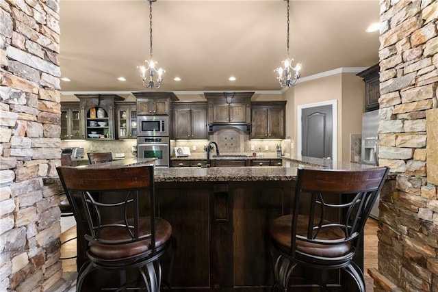 kitchen featuring crown molding, a notable chandelier, appliances with stainless steel finishes, and tasteful backsplash