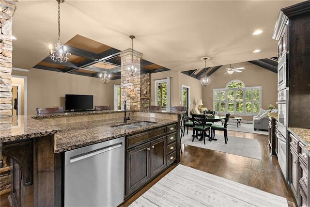 kitchen featuring dark wood-style flooring, stainless steel dishwasher, dark brown cabinets, a sink, and open floor plan