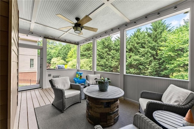 sunroom / solarium featuring plenty of natural light, an outdoor living space, and a ceiling fan