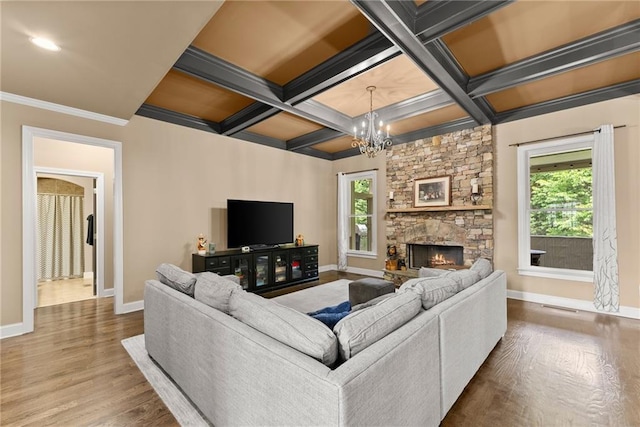 living room featuring an inviting chandelier, baseboards, plenty of natural light, and wood finished floors