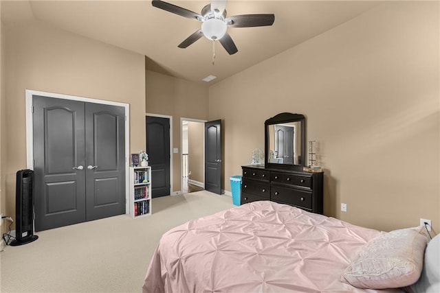 carpeted bedroom with a ceiling fan, high vaulted ceiling, baseboards, and a closet