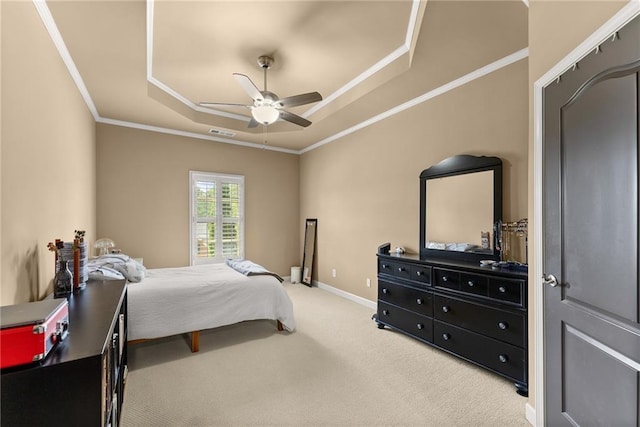 bedroom featuring carpet floors, ornamental molding, visible vents, a tray ceiling, and a ceiling fan