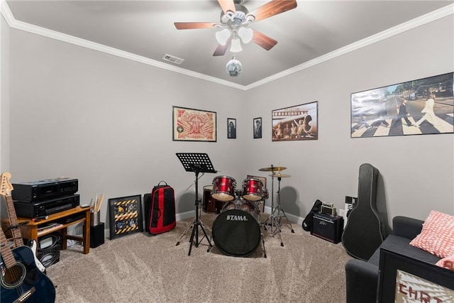 playroom featuring carpet floors, ceiling fan, visible vents, and ornamental molding