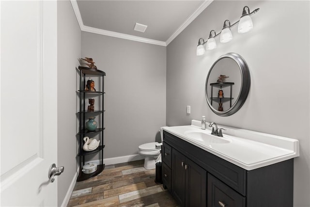 bathroom featuring vanity, toilet, baseboards, wood finished floors, and ornamental molding