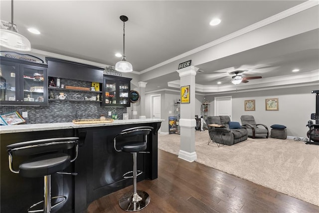 bar with ornamental molding, decorative columns, ceiling fan, wet bar, and backsplash