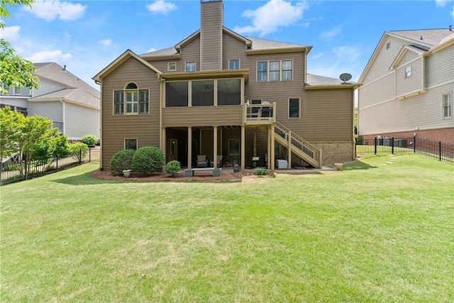 rear view of house with a chimney, a sunroom, stairway, a fenced backyard, and a yard
