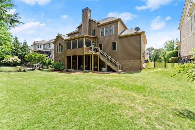 rear view of house with fence, a chimney, a sunroom, a yard, and stairway