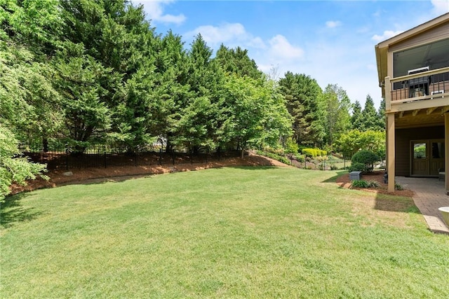 view of yard with fence and a balcony