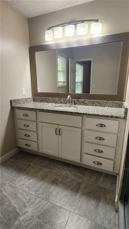 bathroom with a textured ceiling and vanity