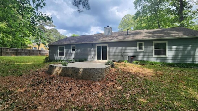 back of house with a chimney, a yard, fence, a patio area, and cooling unit