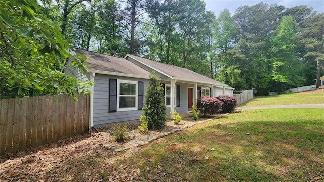 view of property exterior featuring fence and a lawn