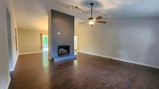 unfurnished living room featuring baseboards, dark wood-style floors, a ceiling fan, a textured ceiling, and lofted ceiling