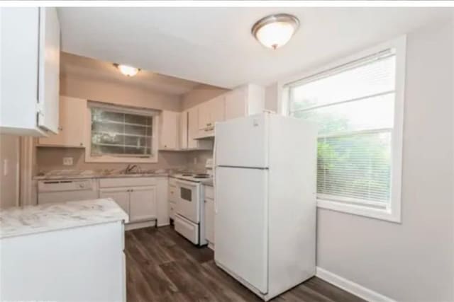 kitchen with white cabinets, dark hardwood / wood-style flooring, and white appliances