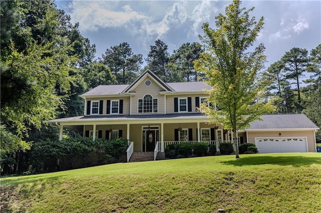 colonial home featuring covered porch, a garage, and a front lawn