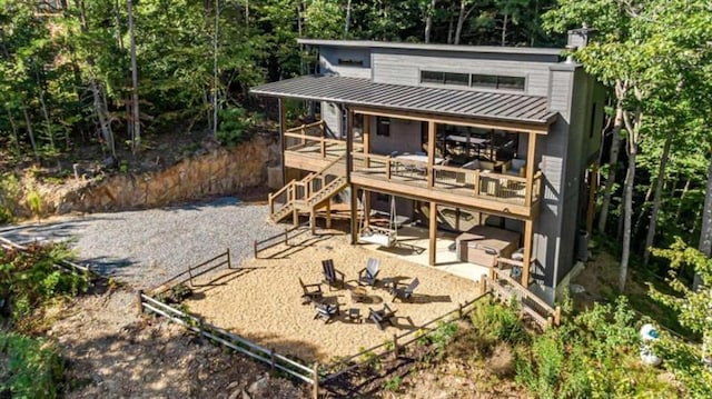 rear view of property featuring metal roof, an outdoor fire pit, stairway, a standing seam roof, and a patio area