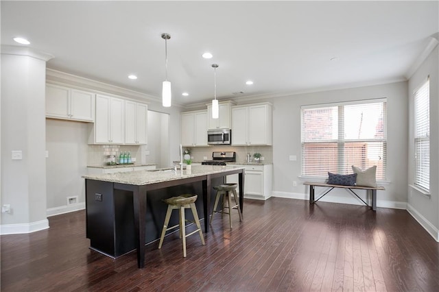 kitchen with dark wood finished floors, decorative backsplash, appliances with stainless steel finishes, and ornamental molding