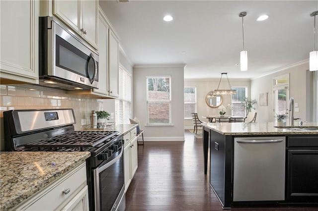 kitchen with a sink, decorative backsplash, appliances with stainless steel finishes, and crown molding