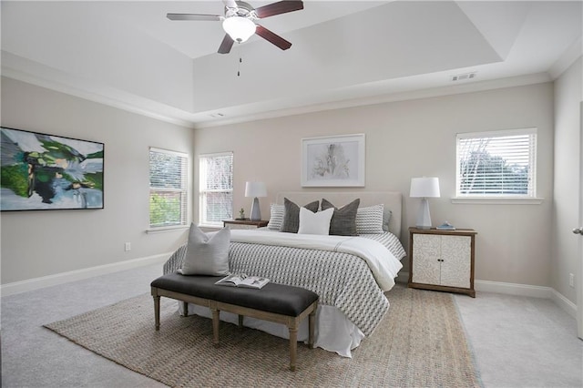 bedroom featuring visible vents, baseboards, a tray ceiling, and carpet floors