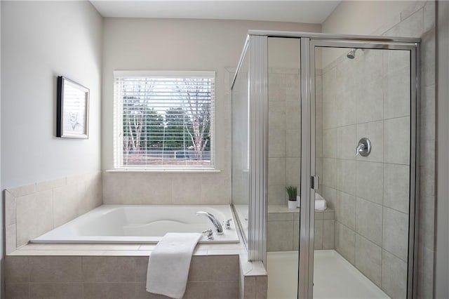 bathroom featuring a garden tub and a shower stall