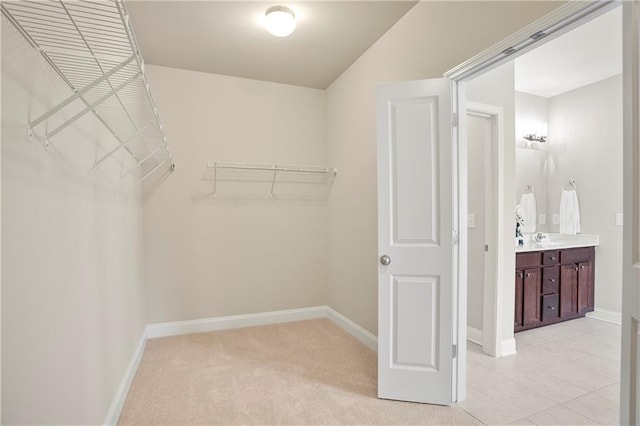 spacious closet with light carpet and a sink