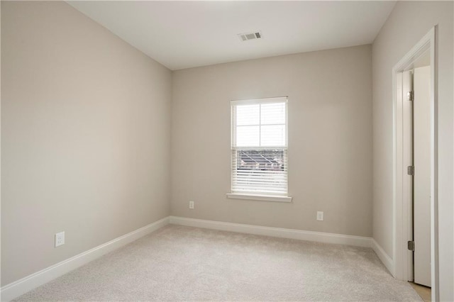 empty room with visible vents, baseboards, and light colored carpet