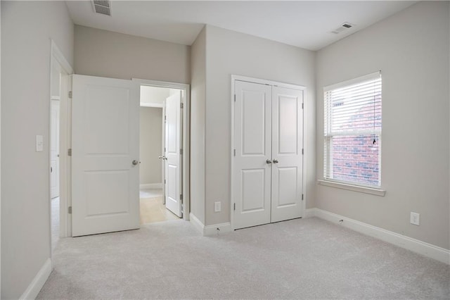 unfurnished bedroom with a closet, visible vents, baseboards, and carpet floors