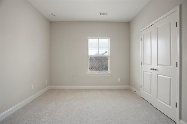 unfurnished bedroom featuring light carpet, visible vents, and baseboards