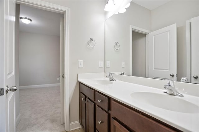 full bathroom featuring a sink, baseboards, and double vanity