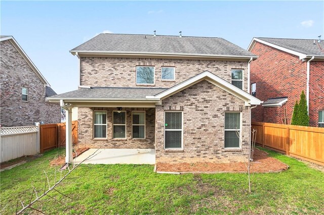 rear view of house with a yard, a patio area, and a fenced backyard