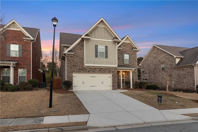 traditional-style home with central AC unit, board and batten siding, concrete driveway, and an attached garage