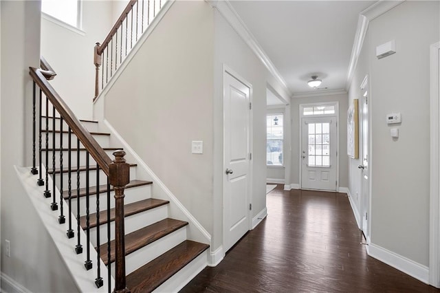 foyer with stairway, wood finished floors, baseboards, and ornamental molding