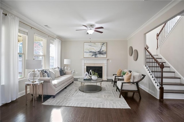 living room with a ceiling fan, stairs, wood finished floors, and ornamental molding