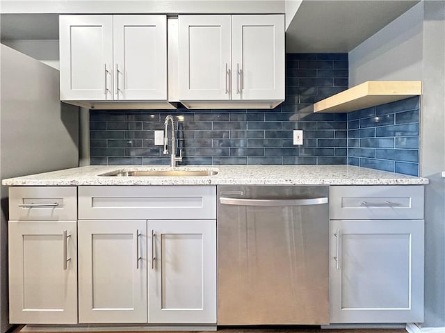 kitchen with light stone countertops, open shelves, a sink, dishwasher, and tasteful backsplash